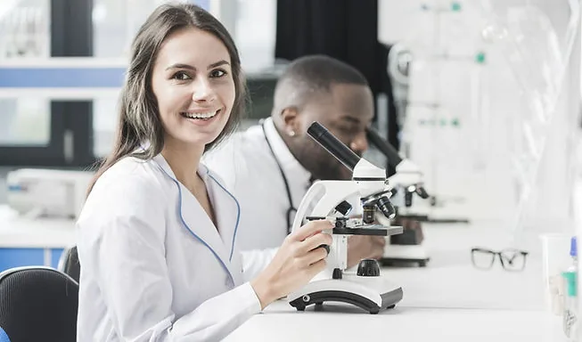 Biomedicina estética. Foto de biomédica mulher utilizando microscópio.