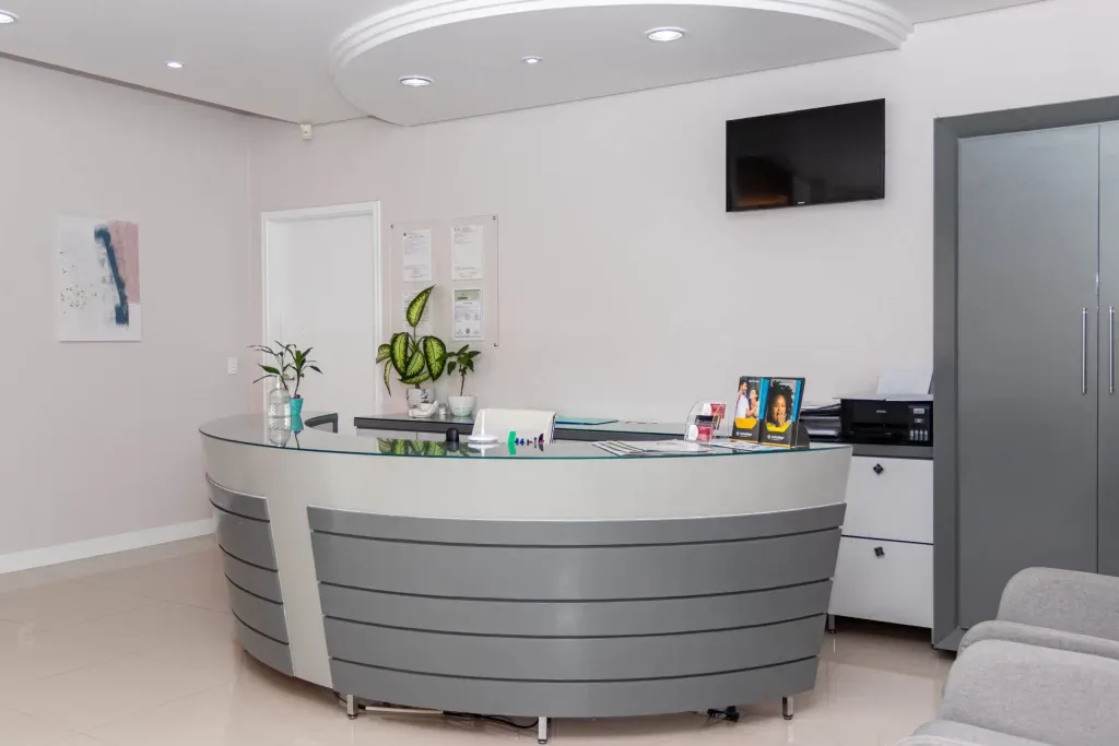 Recepção de clínica odontológica com balcão de atendimento curvo
