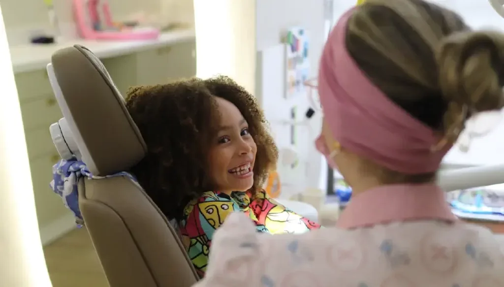 Paciente sorrindo na cadeira odontológica durante o atendimento